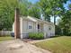 Quaint home featuring vinyl siding, a brick chimney, and a cozy yard, blending charm with practicality at 2600 Newbold St, Raleigh, NC 27603