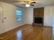 Inviting living room with hardwood floors and a charming brick fireplace, creating a warm and cozy atmosphere at 2600 Newbold St, Raleigh, NC 27603
