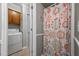 Bathroom next to laundry area with patterned shower curtain, cabinet, and neutral tones at 2614 Cambridge Rd, Burlington, NC 27215