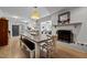 Open dining room with a brick fireplace, hardwood floors, and seating for the whole Gathering at 2614 Cambridge Rd, Burlington, NC 27215