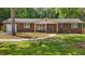 Charming brick home featuring a covered front porch with a swing and a well-manicured lawn at 2614 Cambridge Rd, Burlington, NC 27215