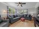 Bright living room features hardwood floors, ceiling fan, and ample natural light from multiple windows at 2614 Cambridge Rd, Burlington, NC 27215