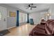 Bright living room with hardwood floors, a ceiling fan, and large windows with blue curtains at 2614 Cambridge Rd, Burlington, NC 27215