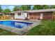 Backyard swimming pool with diving board and access ladder, perfect for summer fun at 2614 Cambridge Rd, Burlington, NC 27215