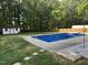 Backyard featuring an in-ground pool with a diving board, surrounded by grass, stepping stones, and a storage shed at 2614 Cambridge Rd, Burlington, NC 27215