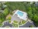 Aerial view of a neighborhood pool and clubhouse, with ample parking and surrounded by lush landscaping at 27 Woodgate Ct, Durham, NC 27713