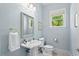 Powder room featuring light blue walls, pedestal sink and a window view at 27 Woodgate Ct, Durham, NC 27713