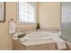 Bright bathroom features a soaking tub and decoratively framed window at 27 Woodgate Ct, Durham, NC 27713