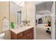 Inviting bathroom featuring a vanity with granite countertop and large mirror, and an open door leading to an entertainment area at 27 Woodgate Ct, Durham, NC 27713