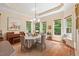 Dining area with hardwood floors, a piano, and a window view of lush greenery, creates a cozy atmosphere at 27 Woodgate Ct, Durham, NC 27713