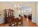 Inviting dining room with a chandelier, hardwood floors, and an arched doorway to the living room at 27 Woodgate Ct, Durham, NC 27713