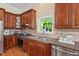 Well-equipped kitchen features stainless steel appliances, granite countertops, and a window overlooking the garden at 27 Woodgate Ct, Durham, NC 27713