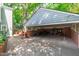Covered parking area featuring brick walls, storage shelves, and landscaping at 2704 Fairview Rd, Raleigh, NC 27608