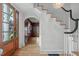 Welcoming foyer with hardwood floors, white staircase, and a view into a formal living space at 2704 Fairview Rd, Raleigh, NC 27608