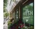 Exterior storefront view of The Fresh Market, featuring bright flowers and outdoor seating at 2704 Fairview Rd, Raleigh, NC 27608