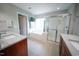 Bright bathroom featuring double vanities, a soaking tub, and a glass-enclosed shower for a spa-like experience at 2711 Laurelcherry St, Raleigh, NC 27612