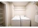 Efficient laundry room with side-by-side washer and dryer and shelving for organized storage at 2711 Laurelcherry St, Raleigh, NC 27612