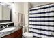 Cozy bathroom featuring a dark vanity with granite countertop and a striped shower curtain at 294 Summerwalk Cir, Chapel Hill, NC 27517