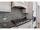 Close up of a kitchen with a gas stove, mosaic tile backsplash, granite countertops and stainless appliances at 3029 Mountain Hill Dr, Wake Forest, NC 27587