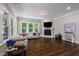 Bright living room with hardwood floors, fireplace, and large windows overlooking the lush greenery at 3029 Mountain Hill Dr, Wake Forest, NC 27587