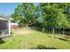 Large, grassy backyard with an outbuilding, playground, and tree swing at 304 Cornelia Dr, Graham, NC 27253