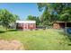 Backyard featuring two outbuildings with surrounding trees and plenty of grass at 304 Cornelia Dr, Graham, NC 27253