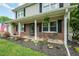 Inviting front porch adorned with flowers, rocking chairs, and an American flag waving in the breeze at 304 Cornelia Dr, Graham, NC 27253