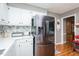 Updated kitchen with stainless steel refrigerator, white countertops and cabinets, plus tile backsplash at 304 Cornelia Dr, Graham, NC 27253