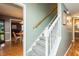 Carpeted staircase with a wooden handrail connects the home's multiple levels at 304 Cornelia Dr, Graham, NC 27253