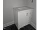 Close-up of a white bathroom vanity with drawers and a cabinet set on black tiled flooring at 305 E Harnett St, Benson, NC 27504