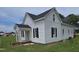 Charming two-story home with a quaint front porch, complemented by black shutters and lush green lawn at 305 E Harnett St, Benson, NC 27504