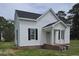 Charming two-story house features a quaint front porch, complemented by black shutters for a touch of elegance at 305 E Harnett St, Benson, NC 27504