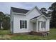 Charming two-story house features a quaint front porch, complemented by black shutters for a touch of elegance at 305 E Harnett St, Benson, NC 27504