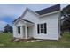 Charming two-story home features a quaint front porch, complemented by black shutters for a touch of elegance at 305 E Harnett St, Benson, NC 27504