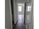 Bright hallway leading to a room with a window and a view, and a bathroom with white cabinet at 305 E Harnett St, Benson, NC 27504