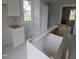 Bright kitchen featuring white cabinetry, marble flooring, and a large window providing natural light at 305 E Harnett St, Benson, NC 27504