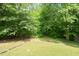 Green backyard shaded by lush mature trees creates a private outdoor space at 306 N Sixth St, Mebane, NC 27302