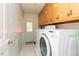 Practical laundry room featuring overhead cabinets, a washer, and a dryer at 306 N Sixth St, Mebane, NC 27302