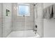 Modern bathroom shower with gray, horizontal tiling and a glass door, promoting a spa-like experience at 308 Furches St, Raleigh, NC 27607