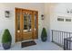 Close-up view of a beautiful wooden front door flanked by potted plants, offering a warm welcome at 308 Furches St, Raleigh, NC 27607