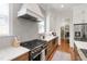 Well-equipped kitchen featuring stainless steel gas range and custom hood with herringbone backsplash at 308 Furches St, Raleigh, NC 27607