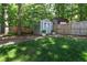 A storage shed in a well-maintained backyard, surrounded by lush greenery and trees at 308 Furches St, Raleigh, NC 27607