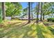 Expansive backyard with mature trees, lawn and a view of a detached garage at 310 Chicopee Rd, Benson, NC 27504