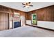 Wood paneled bedroom with two doors, a fireplace, and two windows at 310 Chicopee Rd, Benson, NC 27504