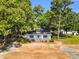 Charming one-story home with a front porch, set amidst mature trees, offering a tranquil and inviting curb appeal at 310 Chicopee Rd, Benson, NC 27504