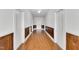 Long hallway with hardwood floors, white walls, and a ceiling fan at 310 Chicopee Rd, Benson, NC 27504