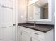 Bathroom with a vanity that has a black countertop, grey walls, and white door at 312 Heidinger Dr, Cary, NC 27511