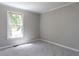 Bedroom with neutral colored walls, grey carpet and a single window overlooking the front yard at 312 Heidinger Dr, Cary, NC 27511