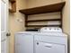 Laundry room with a washer and dryer as well as wooden shelves and a doorway at 312 Heidinger Dr, Cary, NC 27511