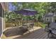 Wooden deck with an umbrella, seating area, and a fenced yard, ideal for outdoor entertaining at 3204 Peachford Ln, Raleigh, NC 27616